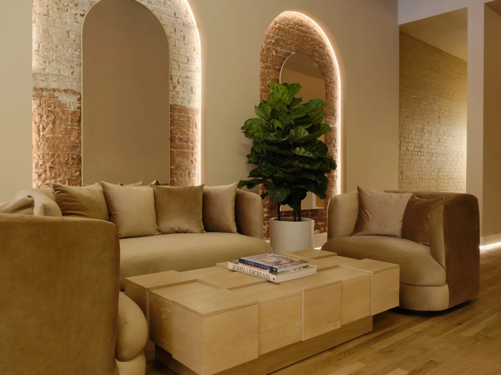 La Reservé Aesthetics medspa waiting area with neutral seating, arched mirrors with ambient lighting, and exposed brick walls in West Village, NY